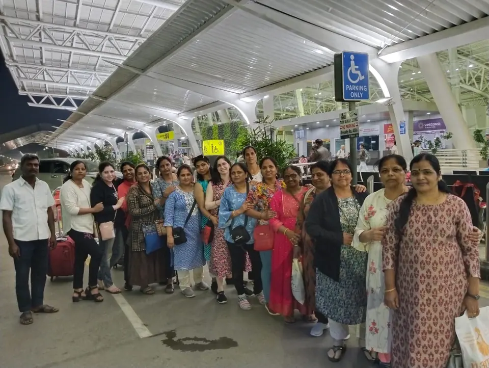 Large ladies group with suitcases at the airport kerb, met by an RKV driver for pickup