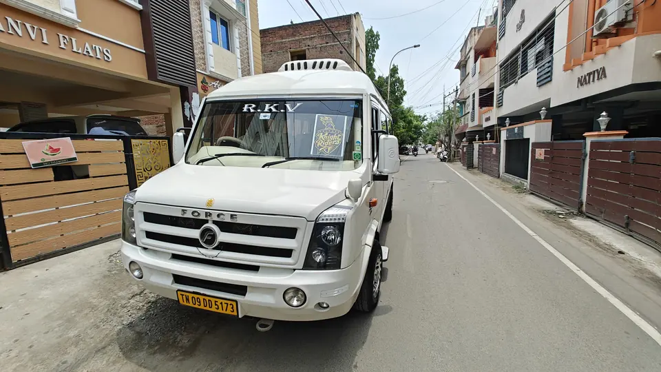 RKV tempo traveller waiting on a quiet residential street in Chennai for a doorstep pickup