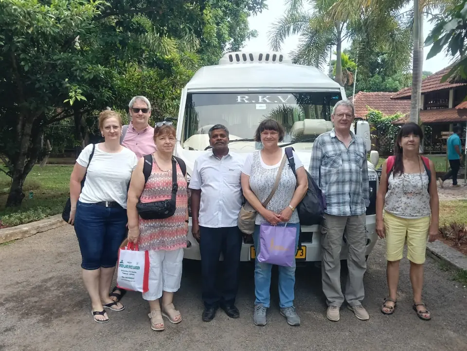 Group of European tourists with their RKV driver in front of a tempo traveller at a resort