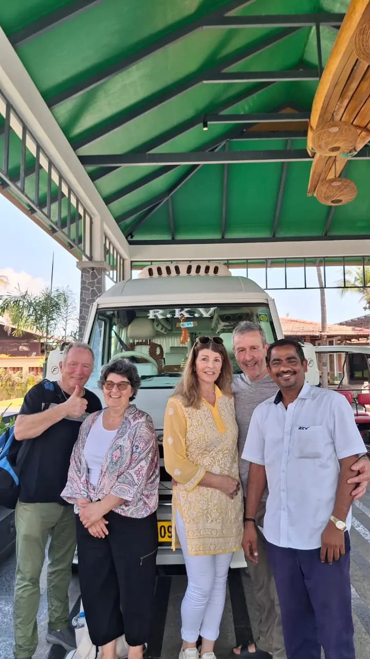 Guests with our driver under a canopy beside the tempo traveller