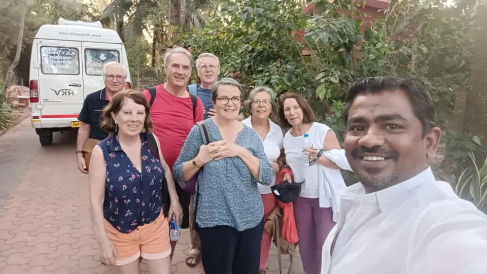 Smiling selfie of our driver with a group of overseas travellers beside the van