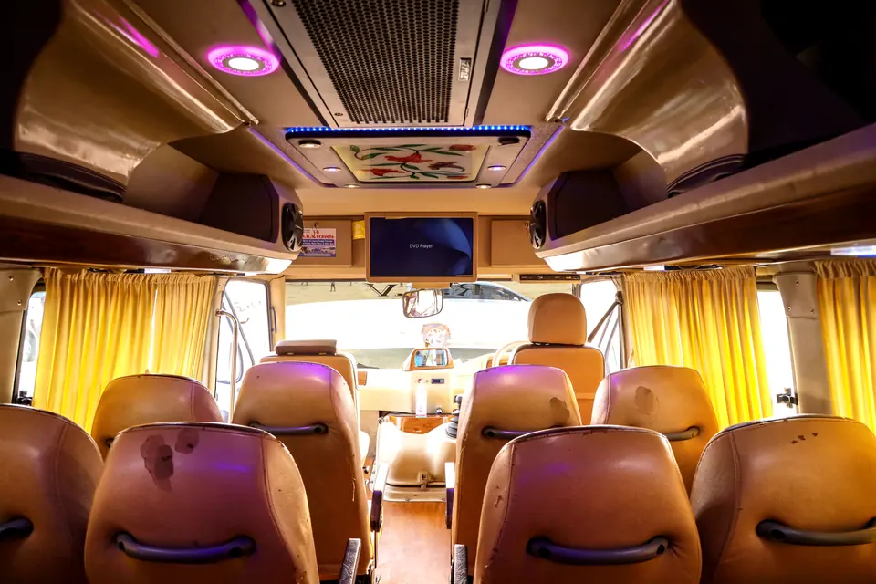 Interior of a luxury tempo traveller with mood lighting, curtains and padded leather seats
