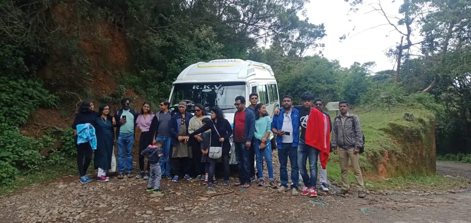 Group of friends with their tempo traveller on a misty forest ghat road