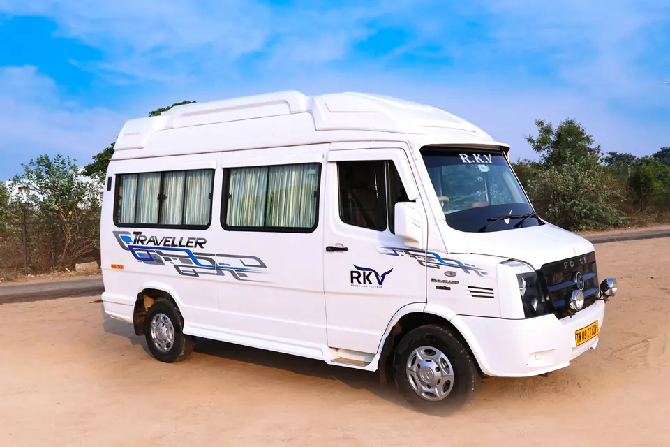 New white Force tempo traveller with RKV blue and yellow livery, front three-quarter view, Chennai