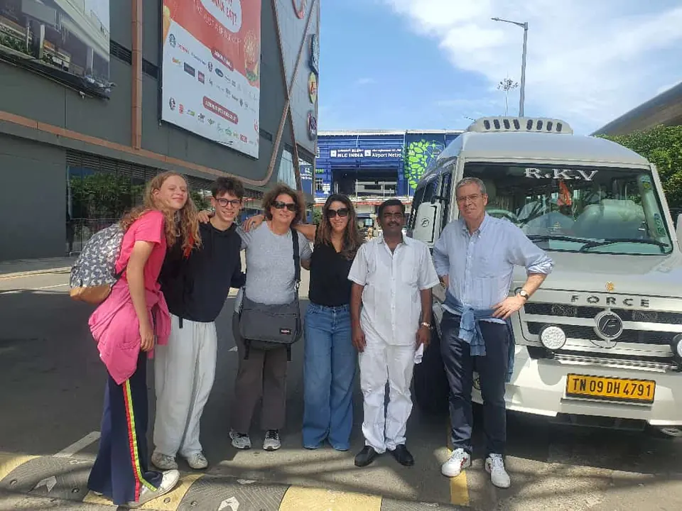 Group of travellers beside an RKV tempo traveller in a shopping street