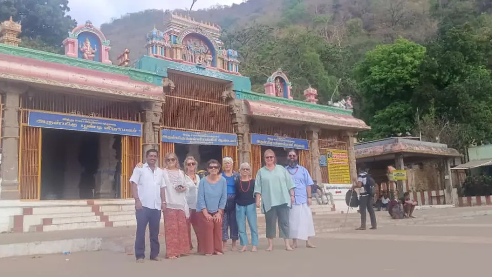Group of overseas visitors with their RKV guide at a hillside temple entrance in Tamil Nadu
