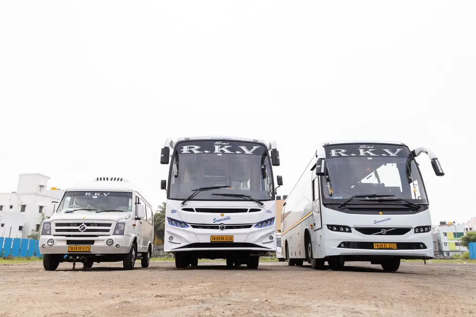 A tempo traveller parked beside two RKV coaches in a Chennai depot
