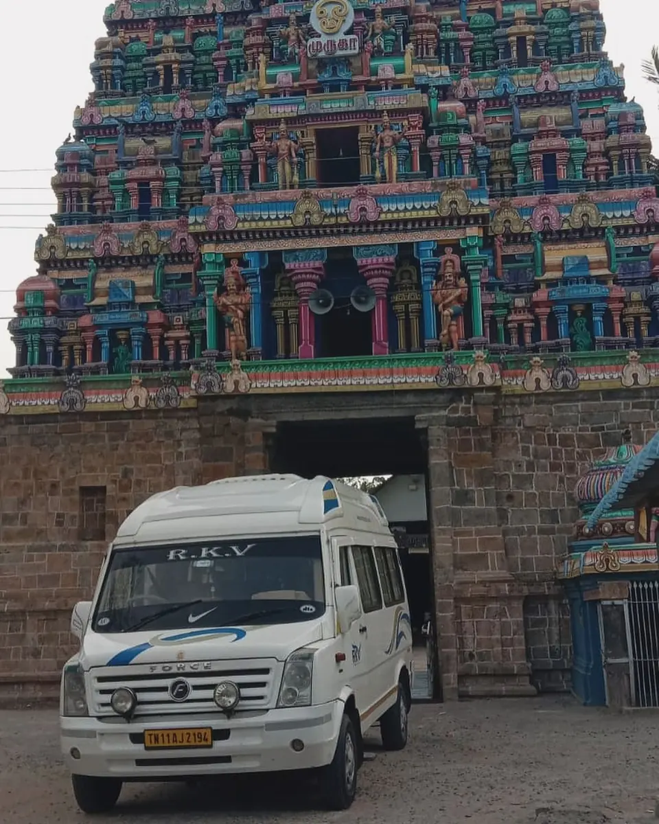 RKV tempo traveller parked beneath a colourful South Indian temple gopuram