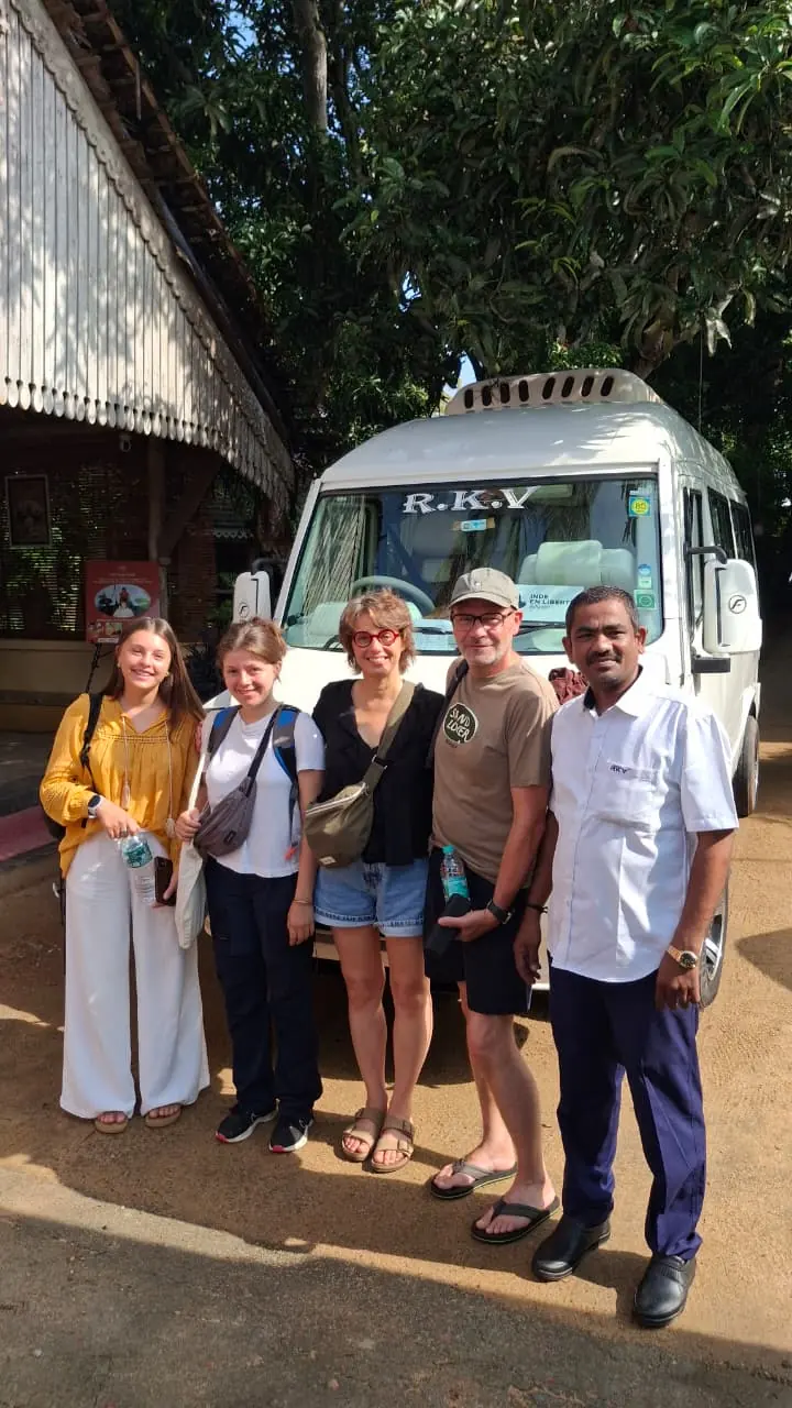 Small tour group with our driver beside a tempo traveller outside a guest house