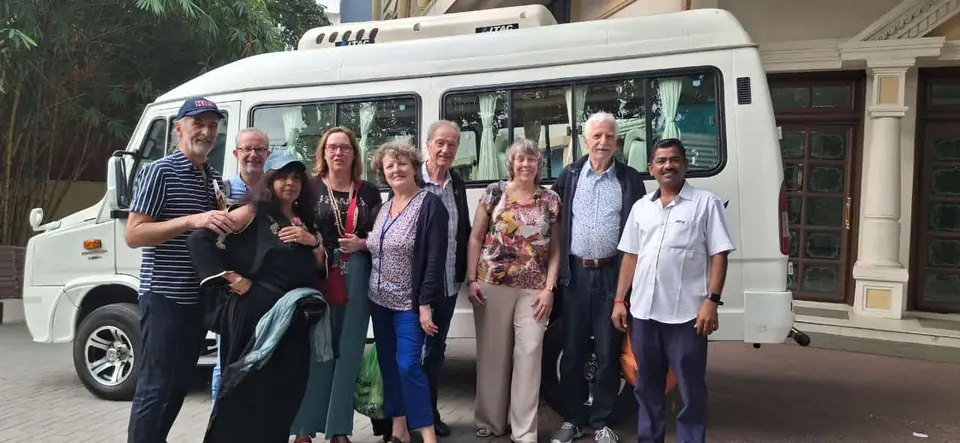 Overseas tourists with our driver beside a long white tempo traveller