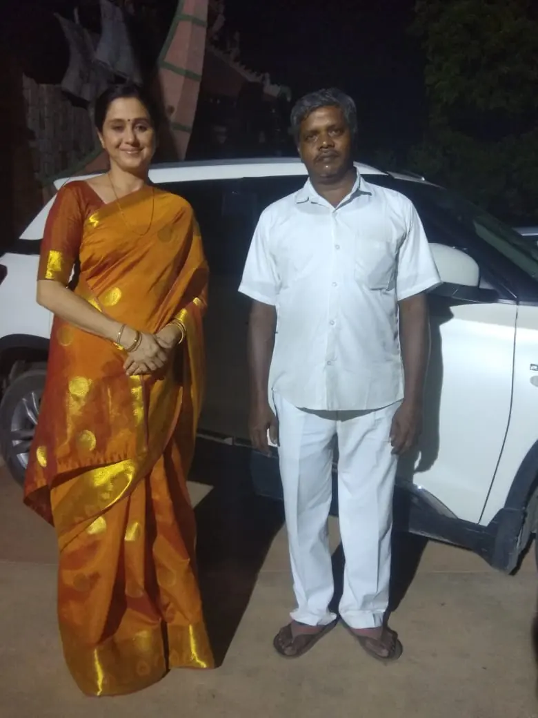 Guest in a silk saree with our uniformed chauffeur at night after a wedding function
