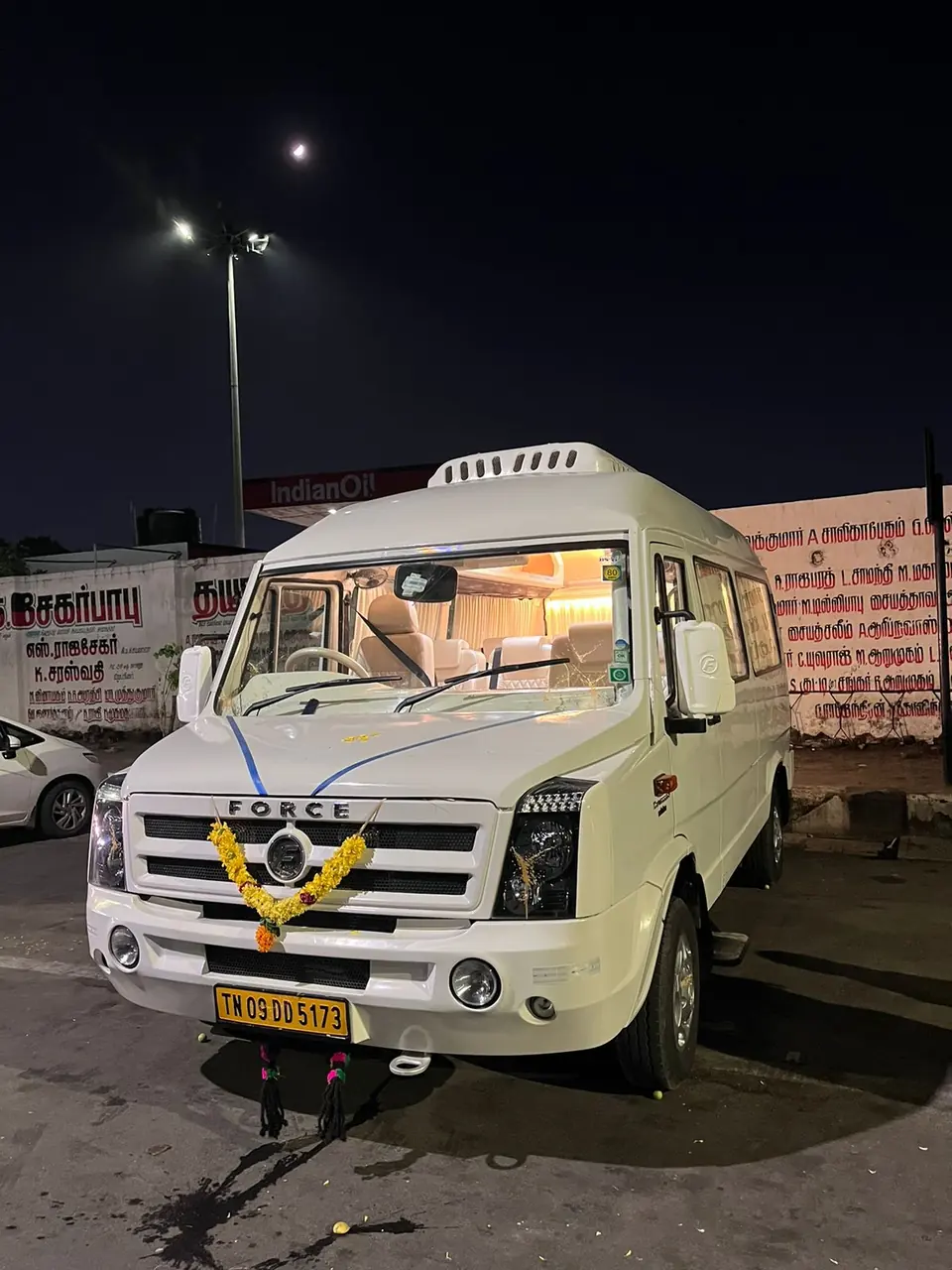 Tempo traveller decorated with a marigold garland at night, ready for a function pickup